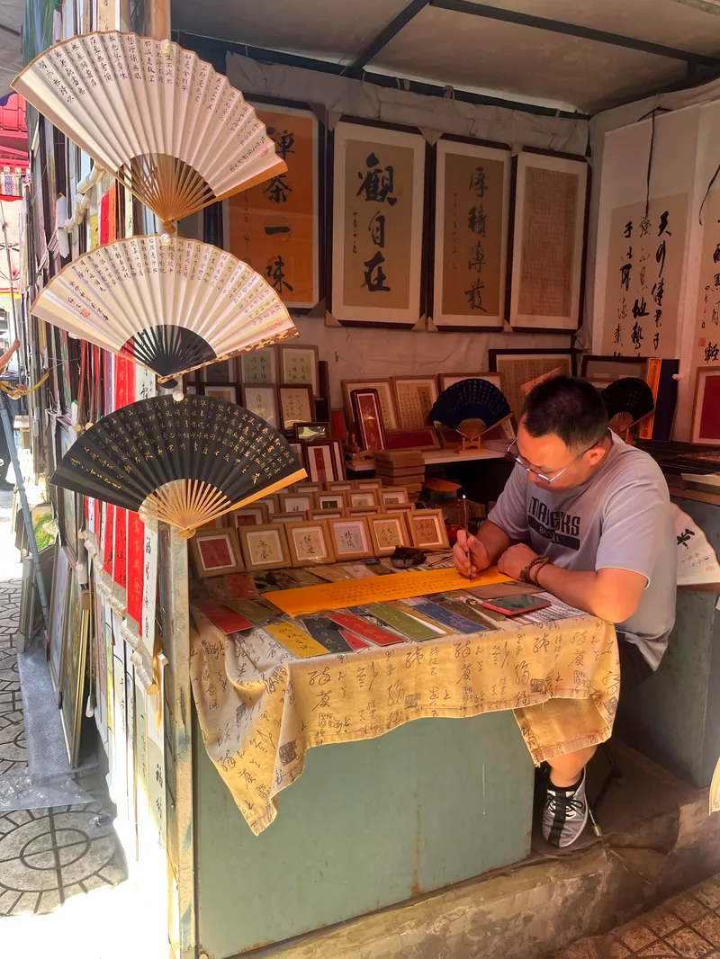 Éventails peints exposés dans un atelier